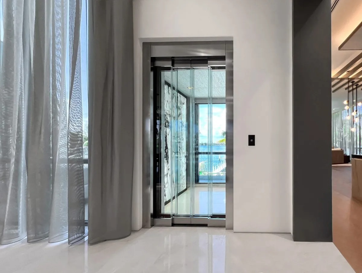 Thang máy gia đình đẹp với cabin 3 mặt vách kính trong suốt và khung cửa Inox tối giản