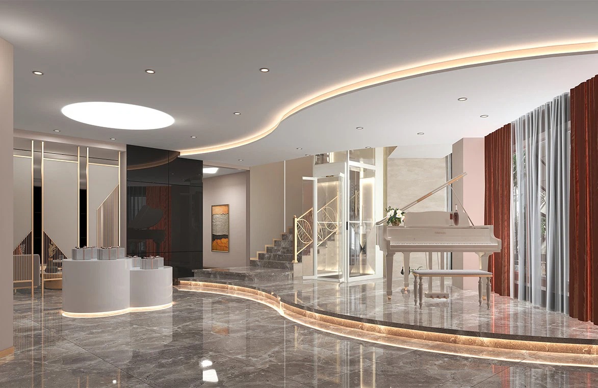 Cabin vuông với vách kính trong suốt toàn phần và khung kim loại màu trắng được lắp đặt cạnh cầu thang bộ